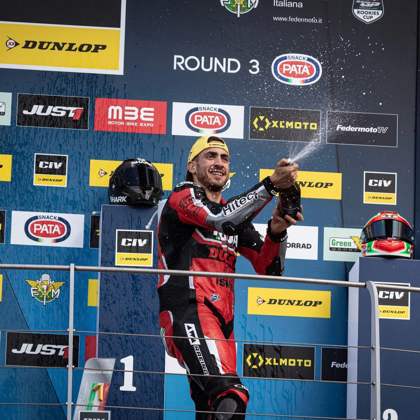 Emanuele festeggia la vittoria sul podio con la tuta Ducati Kuja