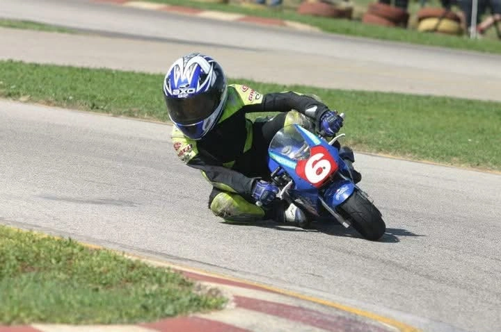 Emanuele in piega sulla minimoto blu con il numero 6